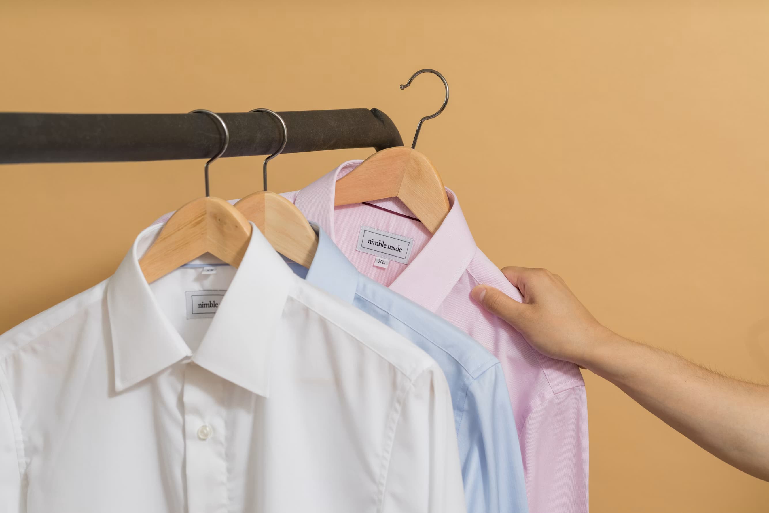 Dress shirts on wooden hangers, ready for formal wear care